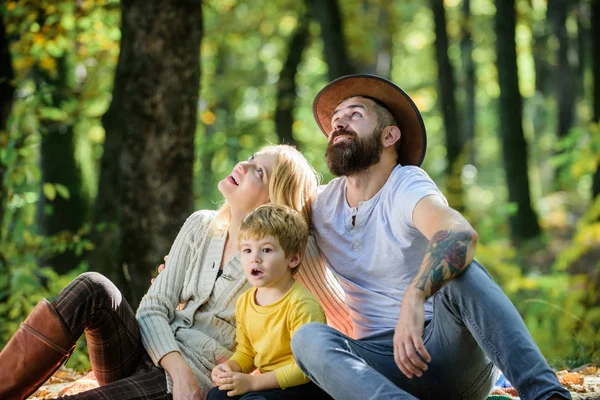 Família feliz com garoto relaxando enquanto caminhava na floresta. Fim de semana familiar. Mãe pai e filho pequeno sentar piquenique floresta. Bom dia para piquenique de primavera na natureza. Unidos à natureza. Conceito de dia familiar — Fotografia de Stock