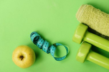 Halter yeşil renkte bükülmüş ölçü bant, meyve ve havlu
