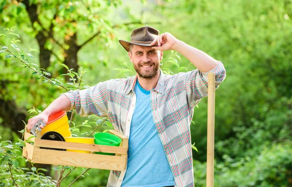 Feliz Dia da Terra. Eco vida. agricultura e cultivo agrícola. Equipamento de jardim. Homem do rancho musculado de chapéu de cowboy. agricultor sexy segurar pá e caixa com pote. Eco trabalhador agrícola. Colheita. Adoro flores. — Fotografia de Stock