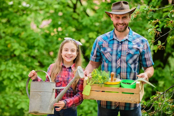 Planting season. Family garden. Maintain garden. Planting flowers. Family dad and daughter planting plants. Transplanting vegetables from nursery or gardening center. Plant your favorite veggies