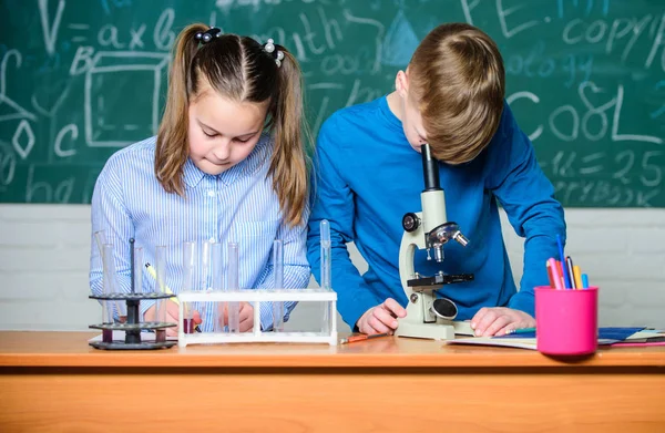 Lección de química escolar. Laboratorio escolar. Educación escolar. Chica y niño se comunican mientras realizan el experimento escolar. Niños estudiando juntos en el aula. Análisis químico. Niños estudian química — Foto de Stock