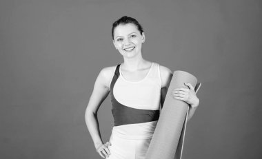 Eğitimden önce ısınıyorum. Yoga sınıfı konsepti. Yoga hobisi ve spor. Her gün yoga pratiği yapıyorum. Zayıf, formda bir sporcu kız, spor minderi tutuyor. Spor ve esneme hareketleri. Kasları esnetiyorum. Atletizm yoga koçu