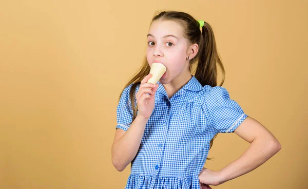 Change the world, one dessert at a time. Adorable kid enjoy frozen iced cream dessert. Small child licking ice cream dessert in waffle cone. Cute little girl eating frozen cream dessert, copy space