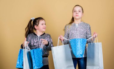 Alışveriş ve satın alma. Kara Cuma. Satış ve indirim. Alışveriş günü. Çocuklar demet paketleri tutarlar. Çocuk modası. Daha fazlasını bekle. Daha az öde. Alışveriş çantaları bej arka plan ile Kız kız kardeş arkadaş