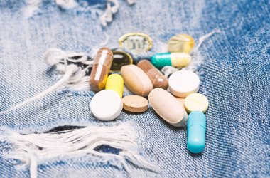 Doz ve bağımlılığı. Uyuşturucu bağımlılığı. İlaç ve tedavi kavramı. Uyuşturucu denim arka plan üzerinde. Renkli hapları kümesi. İlaçlar karıştırma. Hızlı tedavi. İlaç reçete. Sağlık ve hastalık
