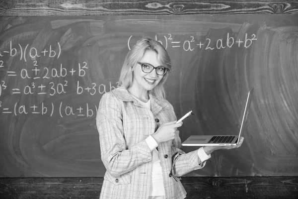 Pädagogin intelligente Dame mit modernem Laptop im Internet surfen Kreidetafel Hintergrund. Grundschulbildung. Lehrerin mit Brille hält Laptop beim Surfen im Internet. Konzept digitaler Technologien — Stockfoto