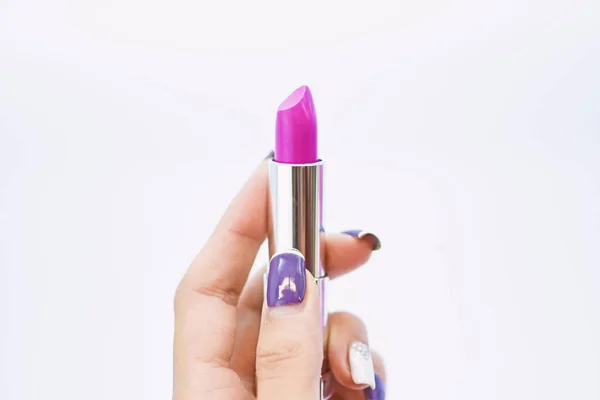 Daily make up. Soft lipstick including balm. Lipstick for professional make up. Lip care concept. Lipstick on white background. High quality lipstick product in female hand. Must have. Beauty trend