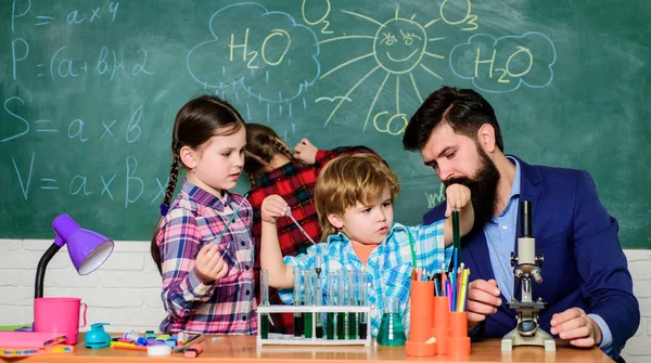 students doing science experiments with microscope in lab. school kids scientist studying science. happy children teacher. back to school. Little kids learning chemistry in school laboratory