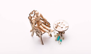 İlaçlar yemeğinden sonra al. İlaç rejimi. Sağlık ve tıbbi tedavi. Küçük ahşap masa hapları. Tablo ilaçlarla yakınındaki insan ahşap kukla. Karmaşık ilaç rejimi mücadele ipuçları