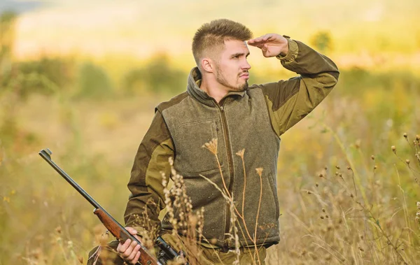 Focus and concentration of experienced hunter. Hunting and trapping seasons. Man brutal gamekeeper nature background. Hunting permit. Bearded hunter spend leisure hunting. Hunter hold rifle