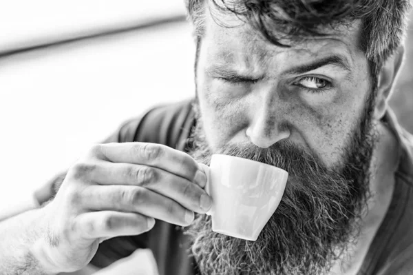 Coffee break concept. Guy relaxing with espresso coffee. Enjoy hot drink. Hipster drinking coffee outdoor. Man with beard and mustache and cup of coffee. Bearded guy relaxing at cafe terrace