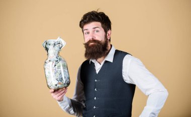 En iyi para yatırımı. Hipster Amerikan parasıyla kavanoz tutuyor. Sakallı adam parayı cam kavanozda tutuyor. İşadamı nakit para tasarrufu