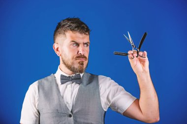 Vintage sanat kavramı berber. Kuaför keskin ustura ile tıraşsız hippi. Berber Kuaför Salonu. İpuçları bakım Kuaför sakal. Erkek yelek papyon ile tutun usturanın mavi arka plan