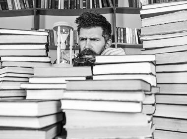 Zaman akışı kavramı. Dostum, bilim adamı bardaklarda kum saati görünüyor. Öğretmen ya da sakal Kitaplığı'nda eğitim ile öğrenci. Adam ciddi yüz izlerken zaman raflardan, arka planda gidiyor