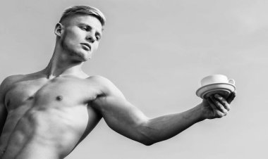 Garson çıplak göğüs kahve fincanı tutun. Seksi gövde çekici garson. Adam kas atlet vücut geliştirmeci kahve sunmaktadır. Maço kas göğüs çıplak gövde tutun fincan taze kahve mavi gökyüzü arka plan