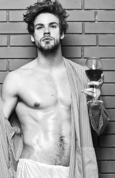 Drink wine and relax. Erotic and desire concept. Guy attractive relaxing with alcohol drink. Man sexy chest sweaty skin hold wineglass. Bachelor enjoy wine. Macho tousled hair degustate luxury wine