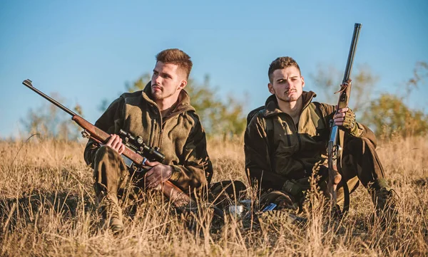 Hunting with friends hobby leisure. Hunters friends enjoy leisure. Hunters satisfied with catch drink warming beverage. Rest for real men concept. Hunters with rifles relaxing in nature environment — Stock Photo, Image