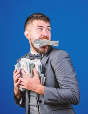 İşadamı sürpriz çok elinde para ile hırsız gibi hissediyor. Para çalmak. Hırsız kazık dolar para ile. Kazanç kavramı sürpriz. Adam iş adamı tutun yığın para mavi arka plan sakallı