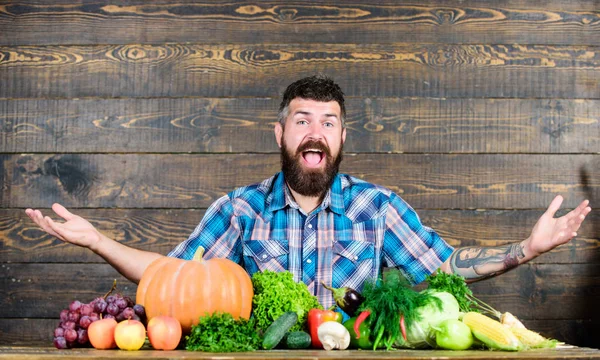 Vegetables organic harvest. Farmer rustic style guy. Vegetarian lifestyle concept. Natural foods. Man bearded farmer harvest wooden background. Welcome to my farm. Farmer with homegrown vegetables