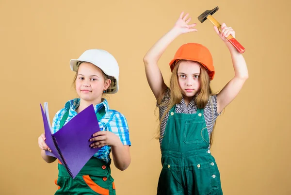 Niños felices. Carrera futura. niñas pequeñas que reparan juntos en el taller. Día del trabajo de parto 1 mayo. Niños pequeños en casco con tableta y martillo. Inspector Foreman. Reparar. niñas pequeñas. niñas pequeñas que trabajan —  Fotos de Stock