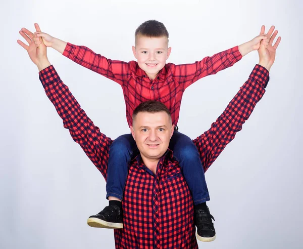 Father little son red shirts family look outfit. Child riding on dads shoulders. Happiness being father of boy. Having fun. Fathers day. Father example of noble human. Family time. Best friends