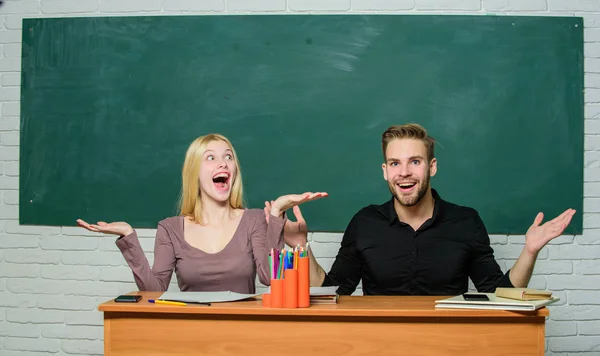 Glücklich und fröhlich. hübsche Lehrerin und gutaussehende Schulleiterin, die am Schreibtisch lächelt. Universitäts- oder Hochschulstudenten. Gymnasialausbildung. Paar, das im Klassenzimmer lernt. Mann und Frau zurück in der Schule — Stockfoto