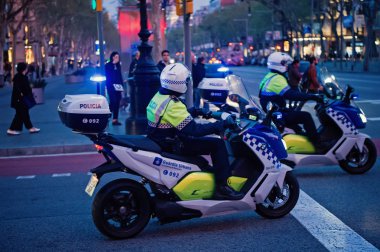Barselona, İspanya, 30 Mart 2016: trafik polisi akşam kavşak üzerinde motosiklet. Kentsel arka plan üzerinde devriye polisi. Devriye ve polis koruması. Taşıma için polis Barcelona, İspanya