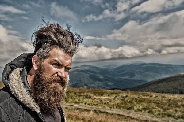 Uomo hipster con lunghi capelli barba sul paesaggio montano — Foto Stock