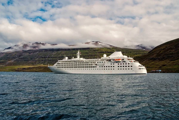 Navegando por placer. Crucero en el mar en el paisaje de montaña en Sejdisfjordur, Islandia. Transatlántico en el mar con montañas en cielo nublado. Vacaciones de verano y viaje. Aventura y descubrimiento — Foto de Stock
