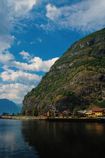Χωριό σε Flam, Νορβηγία. Εξοχικές κατοικίες στο κύμα της θάλασσας, σε ορεινό τοπίο. Στα φιόρδ και τα βουνά στο συννεφιασμένο ουρανό. Διακοπές και περιπλάνησης. Ταξίδι και την ανακάλυψη — Φωτογραφία Αρχείου