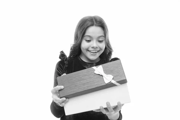 Pequena menina bonito recebeu presente de férias. O que está dentro. Melhores brinquedos e presentes de Natal para crianças. Menina criança em elegante vestido encaracolado penteado segurar caixa de presente. Criança animado sobre a desembalagem de seu presente — Fotografia de Stock