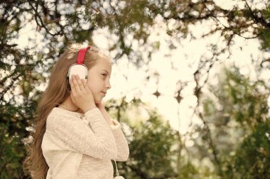 Güzel küçük kız kulaklıkla müzik dinlemekten hoşlanıyor.