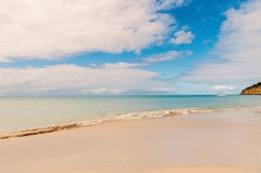 Pastoral sahne kum tropik sahil dalga mavi deniz. Herkes tropic resort st.johns antigua ziyaret etmeniz gerekir. Üst listesi tatil tatil. Tropic ada tatil seyahat. Çarpıcı güzellik tropic çevre
