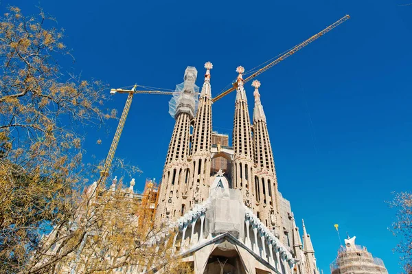 Barcellona, Spagna - 30 marzo 2016: Sagrada familia e gru sul cielo blu. Basilica e chiesa espiatoria della Sacra Famiglia. Cattolico romano. Design Gaudì. Architettura e stile. Punto di riferimento e visite turistiche — Foto Stock