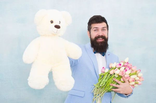 Dia das mulheres. Homem de negócios formal com ursinho de pelúcia brinquedo. Buquê de primavera. 8 de março. noivo de noiva na festa de casamento. Homem barbudo em gravata borboleta com flores de tulipa. encontro de amor com flores. Feliz Aniversário — Fotografia de Stock