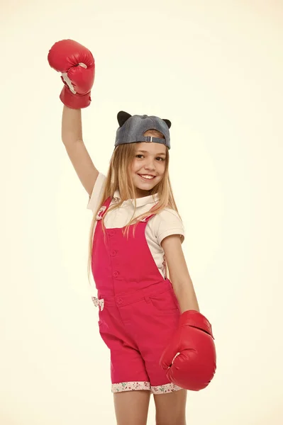 Girl on smiling face posing with boxing gloves, isolated on white background. Girl likes boxing and sporty lifestyle. Kid girl with long hair knows how to defend herself. Girls power concept