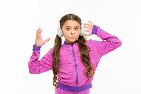Czas odpoczynku. Aktywna dziewczyna cieszyć się muzyką grając w słuchawkach. Athletic dziewczynka relaks na białym tle. Cute Girl dziecko słuchania muzyki. Dopasuj małą dziewczynę do noszenia słuchawek — Zdjęcie stockowe