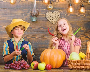 Children presenting farm harvest wooden background. Reasons why every child should experience farming. Farm market. Siblings having fun. Kids farmers girl boy vegetables harvest. Family farm