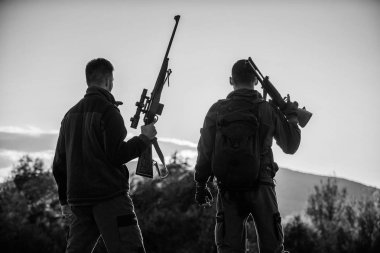 Avcı tüfekler doğa ortamı. Bu harika bir gündü. Av sezonu bitirmek. Günbatımı dağlarda zevk. Avcılar arkadaşlar eğlence keyfini çıkarın. Gökyüzü arka plan avcılar arkadaşlar gamekeepers silahlı siluet