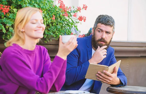 Su primer encuentro en la cafetería. Primer encuentro de chica y hombre maduro. Pareja enamorada en una cita romántica. Café matutino. Brutal barbudo hipster y chica beben café. mujer y hombre con barba relajarse en la cafetería — Foto de Stock