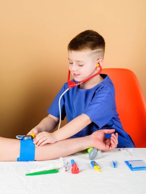 Tıp eğitimi. Çocuk sevimli çocuk gelecek doktor kariyer. Sağlık. Çocuk küçük doktor steteskop ve tıbbi aletlerle masaya otursun. Tıp kavramı. Kan basıncını ölçmek. Tıbbi muayene
