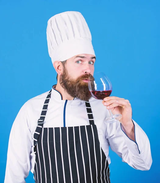 This is perfect wine. Happy bearded man. This wine is just perfect. Confident male sommelier examining glass with wine. Professional chef in cook uniform. Alcoholic drink. Red wine in glass