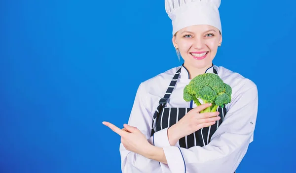 Köchin hält Brokkoli in der Hand und zeigt auf den Kopierraum. gesunde vegetarische Rezepte. erstaunliche Brokkoli-Fakten, die Sie kennen sollten. Gesunde Ernährung. Diätkonzept. gesund ernähren. Mädchen halten Gemüse. Bio-Ernährung — Stockfoto