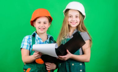 Sana nasıl yardım edebilirim. küçük kızlar atölyede birlikte tamir. Foreman müfettişi. Onarım. İşçi bayramı. 1 mayıs. okul projesi. Mutlu çocuklar. Tabletli kasklı küçük çocuklar