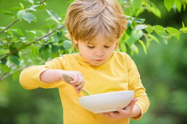 oğlu ve süt lapası yemek. kahvaltıda mısır gevreği. Günaydın. küçük çocuk açık yemek. Çocuk gelişimi. Küçük çocuk sağlıklı yemek yer. çocukluk mutluluğu. sağlıklı gıda ve diyet. Aile günü