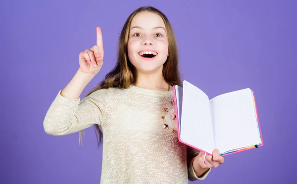 Got great idea. Happy little girl holding open idea book and keeping finger raised. Smiling small child having an idea. Idea came into her head, copy space — Stock Photo, Image