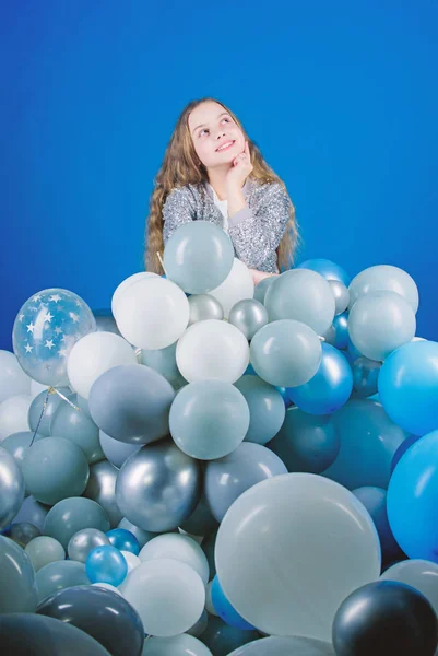 A planear a festa de anos dela. Criança atenciosa à espera do tempo da festa. Criança pequena com balões de festa. Embalando seu local da festa com lotes de balões de ar — Fotografia de Stock