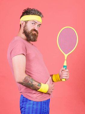 Tenis kilo vermek için etkili bir yol olabilir. Tenis spor. Tenis Kulübü kavramı. Adam hipster giyim eski okul spor kıyafeti bandaj ile sakallı. Elinde kırmızı bir arka plan üzerinde atlet tutun tenis raketi