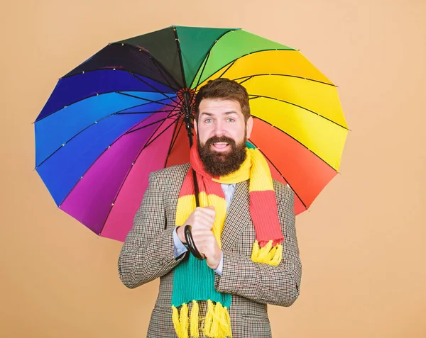 Передбачити майбутні погодні тенденції. Чоловік бородатий хлопець тримає барвисту парасольку. Здається, йде дощ. Дощові дні можуть бути важкими для проходження. Підготовлений до дощового дня. Безтурботний і позитивний. Насолоджуйтесь дощовим днем — стокове фото
