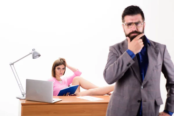 Preparing for coach training. Sexy woman coach working while bearded man standing in foreground. Business coach sitting at desk. Sensual career coach and man worker in office. Coaching career
